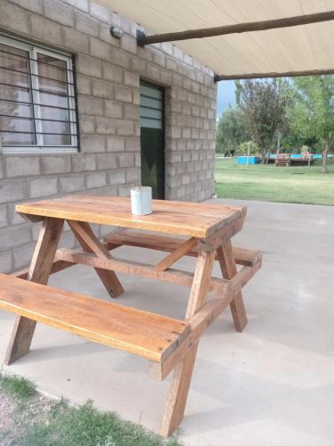 una mesa de picnic de madera con 2 bancos frente a un edificio en Nostraterra en San Rafael