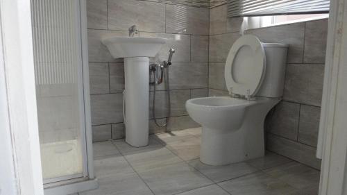 a bathroom with a toilet and a sink at Modern Studio in Rayners Lane Pinner Harrow near wembley Greater London in Pinner