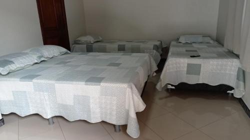 2 letti posti in una stanza con sedie di Maura oliveira a Boa Vista