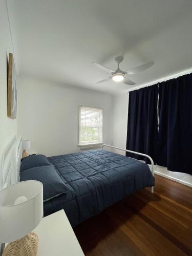 a bedroom with a bed and a ceiling fan at Sea Salt Cottage - Bring your own linen. in South West Rocks