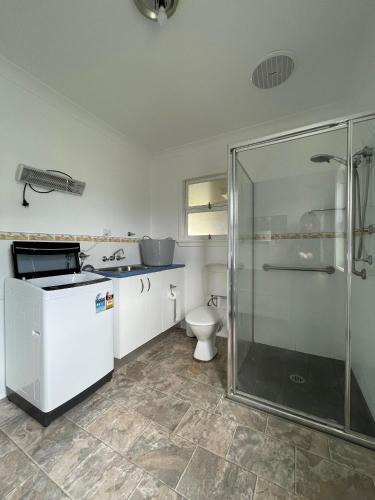 a bathroom with a shower and a toilet at Sea Salt Cottage - Bring your own linen. in South West Rocks