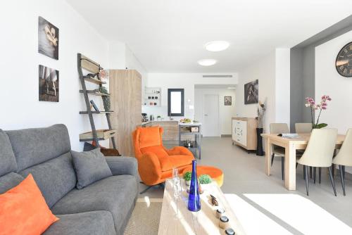 a living room with a gray couch and an orange chair at Las Yucas 2 by VillaGranCanaria in Arguineguín