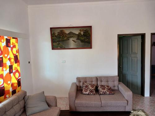 sala de estar con sofá y una foto en la pared en Olosara Haven, en Sigatoka