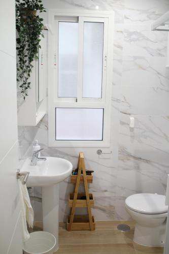 ein Bad mit einem Waschbecken, einem WC und einem Fenster in der Unterkunft LUISAHOUSE, en el corazón de Sevilla y Triana in Sevilla