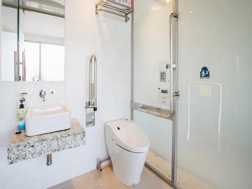 a white bathroom with a toilet and a sink at La Villa Hotel in Seoul
