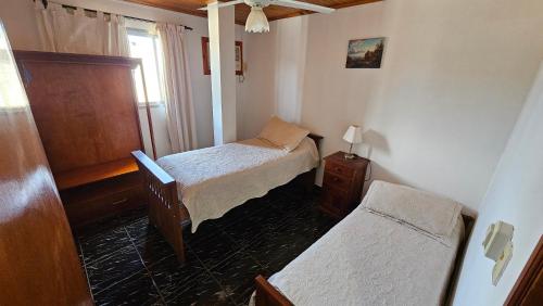 Habitación pequeña con 2 camas y ventana en Casa Giovanini en Puerto Iguazú