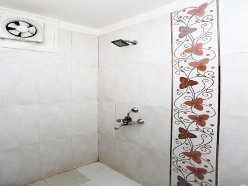 een douche met een bloemontwerp aan de muur bij Hotel Blossom Family Rooms in Nagla Dhīmar