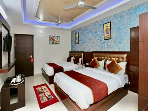 um quarto de hotel com duas camas e uma televisão em Hotel The Blue rose 500mtr Taj em Tājganj