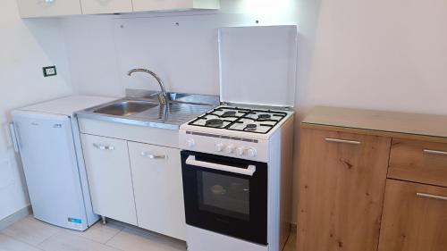 una cucina con piano cottura e lavandino di Passariello a Ischia