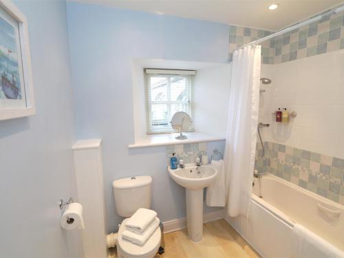 a white bathroom with a toilet and a sink at 3 Bed in Nr Bamburgh CN035 in Belford