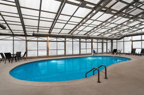 a large swimming pool in a building with windows at La Quinta by Wyndham Chicago Tinley Park in Tinley Park