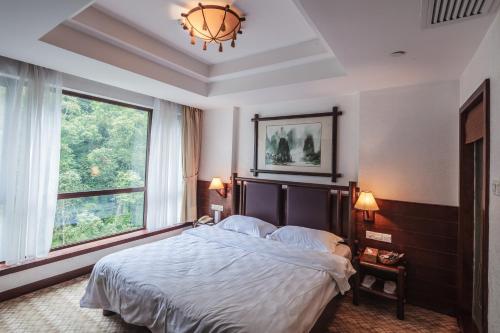 una camera con un letto e una grande finestra di Longsheng Hot Spring Resort a Longsheng