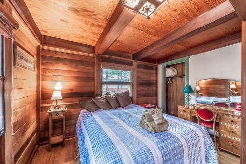 a bedroom with a bed and a wooden ceiling at Deer Meadows: Adorable, Centrally Located Ruidoso Cabin with Private Hot Tub! in Ruidoso