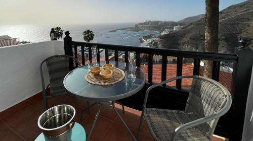 een tafel op een balkon met uitzicht op de oceaan bij Canarios III SeaView in Patalavaca
