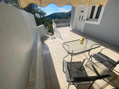 a patio with a table and chairs on a balcony at Home Apartments in Parga