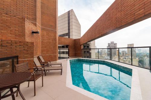 a swimming pool on the roof of a building at LFlats no Hotel Hampton Park Jardim Paulista in Sao Paulo