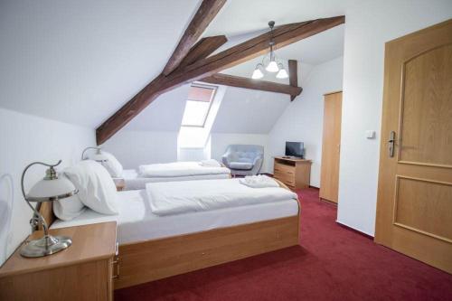 a bedroom with a bed and a desk and a chair at Hotel Zámeček Raspenava in Raspenava