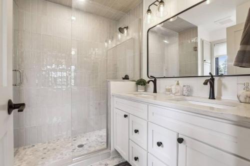 een witte badkamer met een wastafel en een douche bij Luxury Hastings Home, Sleeps 18+ in Hastings