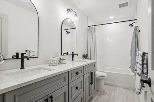 a white bathroom with a sink and a toilet at Luxury Hastings Home, Sleeps 18+ in Hastings
