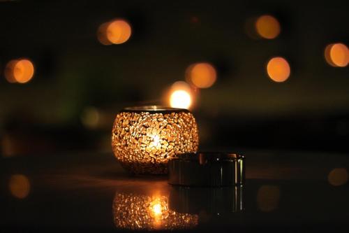 a candle sitting on a table with lights in the background at The Temple House in Chengdu