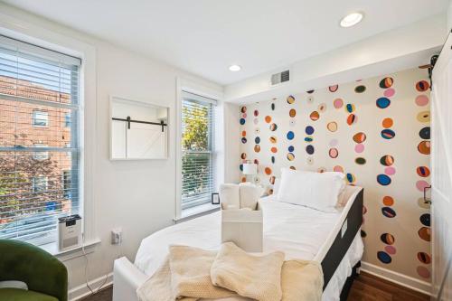 a bedroom with a white bed and a colorful wall at Federal Hill Luxury + City Charm in Baltimore