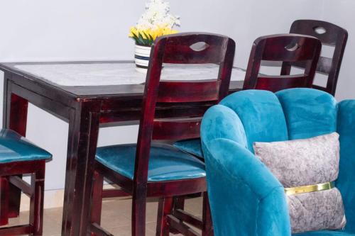 einen Tisch mit 2 Stühlen und eine blaue Couch in der Unterkunft elegant luxury 2 bedroom mombasa wifi two balconies in Mombasa
