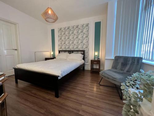 1 dormitorio con 1 cama y 1 silla en One-Bedroom Flat with Parking and Garden, en Birmingham