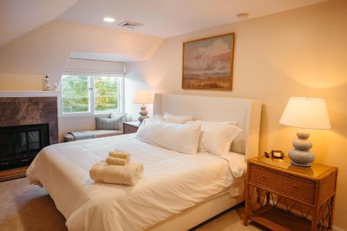 ein Schlafzimmer mit einem großen weißen Bett und einem Kamin in der Unterkunft Clackamas Riverfront GuestHouse, Sauna & HotTub in Oregon City