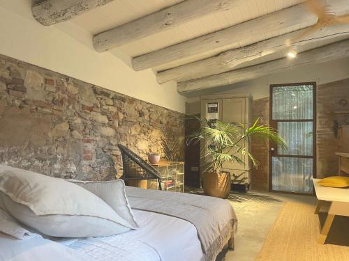 a bedroom with a bed and a stone wall at L'ESTABLE DE CAN TABERNER in Bigues i Riells