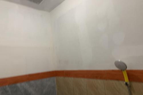 a broom in a room with a white wall at Mozza guest house in Klaten
