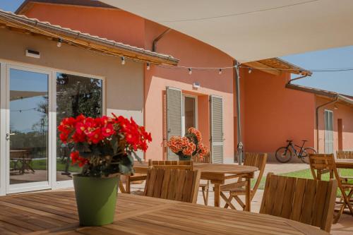 une terrasse avec une table en bois et des fleurs rouges dans l'établissement Borgo Sant'Anna, à Bettona