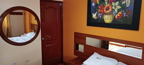 een slaapkamer met een spiegel en een bed en een sidx sidx sidx bij Hotel Allison in Huacho