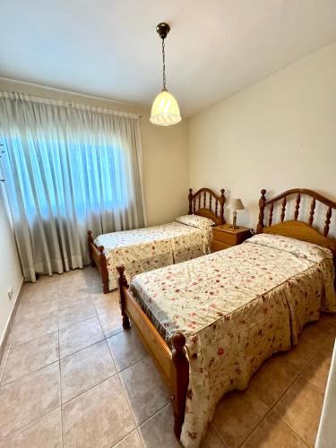 a bedroom with two beds and a window at Departamento frente al Shopping ,B 8 in Guaymallen