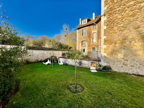 un petit arbre dans la cour d'un bâtiment dans l'établissement La sapinière, duplex de charme, à Hermanville-sur-Mer