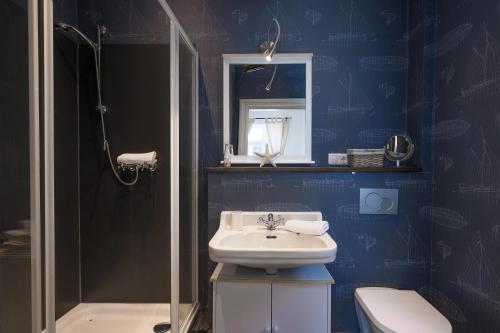 a blue bathroom with a sink and a toilet at Lodge am Oxenweg in Husum