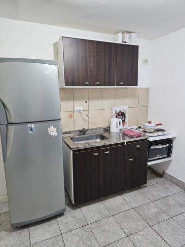 a kitchen with a refrigerator and a sink at Departamento cómodo y confortable in Río Grande