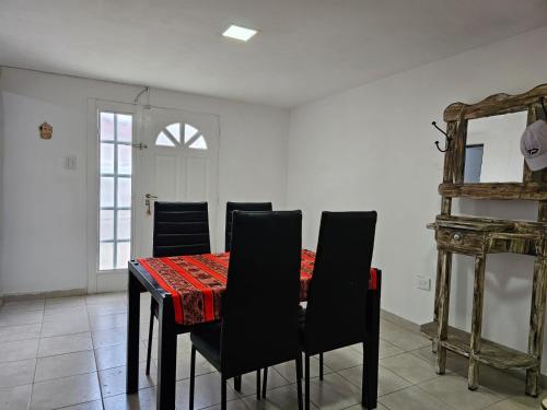 uma sala de jantar com uma mesa com cadeiras e um espelho em Departamento cómodo y confortable em Rio Grande