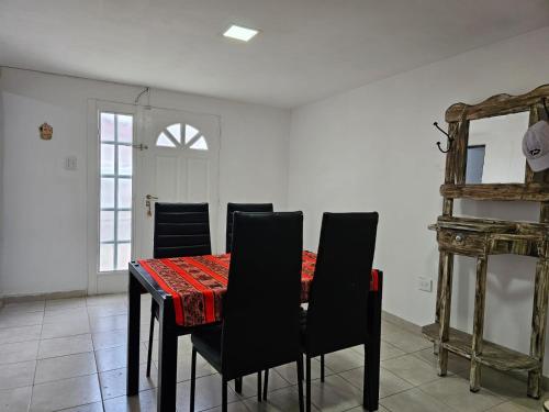 a dining room with a table with chairs and a mirror at Departamento cómodo y confortable in Río Grande