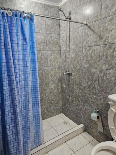 uma casa de banho com um chuveiro com uma cortina de chuveiro azul em Departamento cómodo y confortable em Rio Grande