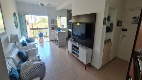 a living room with a couch and a flat screen tv at Apto diferenciado em Ubatuba in Ubatuba