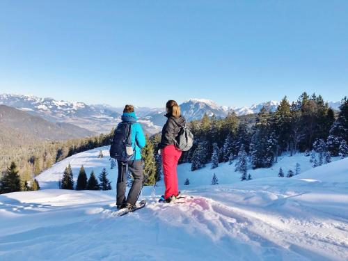 two people standing on top of a snow covered mountain at Open Garden Mountain Lodge in Oberaudorf