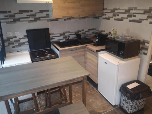 une cuisine avec une cuisinière et un réfrigérateur dans l'établissement Voisenon village paisible Gare de lyon 25mn RER accès A5 à 10mn Paris 5mn proche de Melun château de vaux le vicomte Fontainebleau proche, à Voisenon