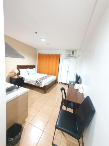 a hotel room with a bed and a table and chairs at Sab R. Bel air soho in Manila