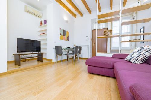 een woonkamer met een paarse bank en een tafel bij Casa Navigli - Cozy Apartment in Milaan