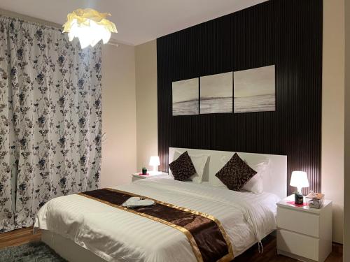 a bedroom with a large bed with a black wall at إطلالة بحرية عوائل فقط KAEC Star Sea View in King Abdullah Economic City