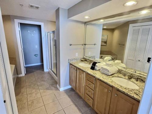 a bathroom with two sinks and a large mirror at 4 Bedroom Luxury High Rise Corner Condo with 2 Balconies, Heated Pool, Direct Beach Access in Gulf Shores