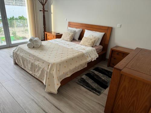 a bedroom with a bed with a teddy bear on it at MIRANDA HOUSE in Nazaré