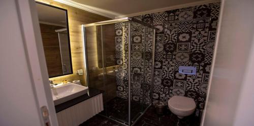 a bathroom with a shower and a toilet and a sink at MIR'AMOR GARDEN Resort Hotel-ALL INCLUSIVE in Antalya