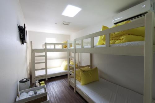 Pokój z 2 łóżkami piętrowymi i żółtymi poduszkami w obiekcie 24 Guesthouse Myeongdong Town w Seulu