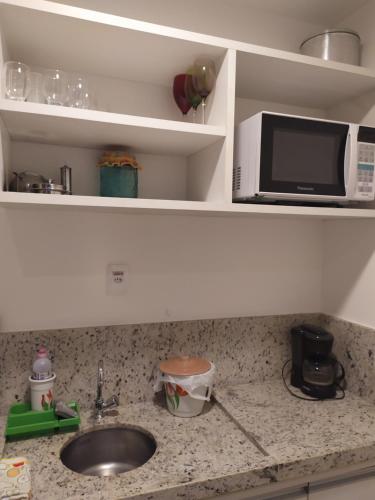 a kitchen counter with a sink and a microwave at Studio Moderno bem localizado in Feira de Santana